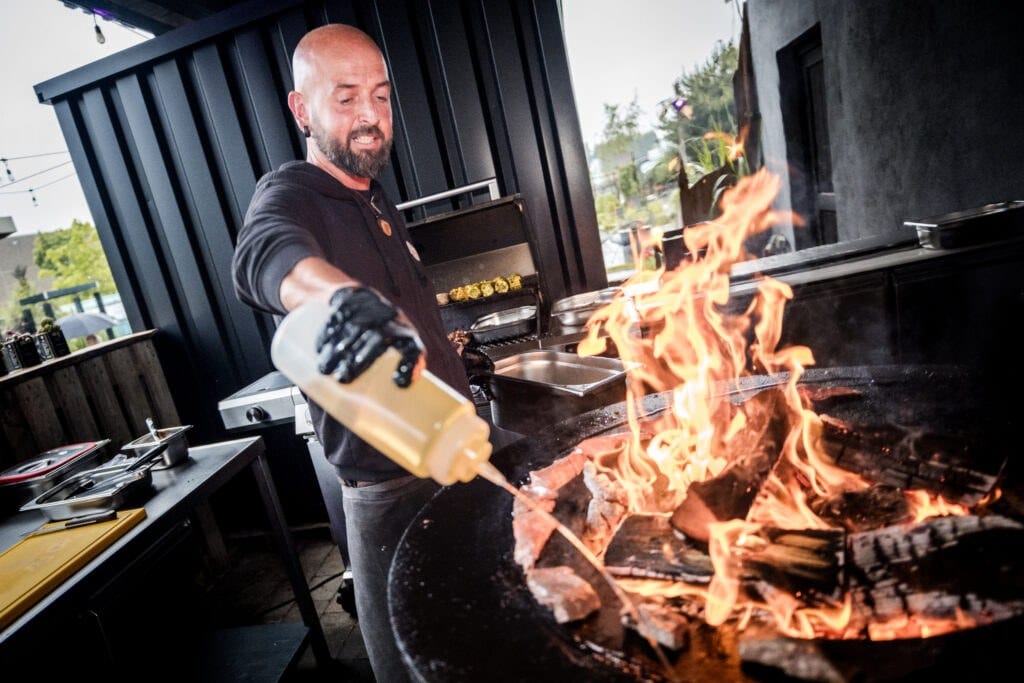 Eventkoch grillt live auf offener Feuerplatte bei einer Hochzeit in der Manufraktur in Neu-Ulm